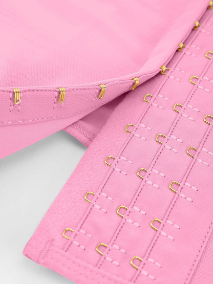 Close-up of pink fabric with gold hook and eye closure on a white background