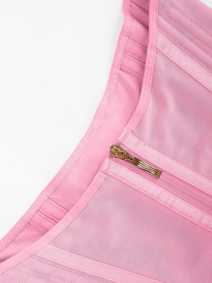 Close-up of a pink garment with a gold zipper on a white background